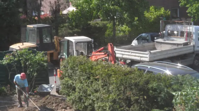 Maschinen und Fahrzeug bei Arbeiten an einer Hofstelle