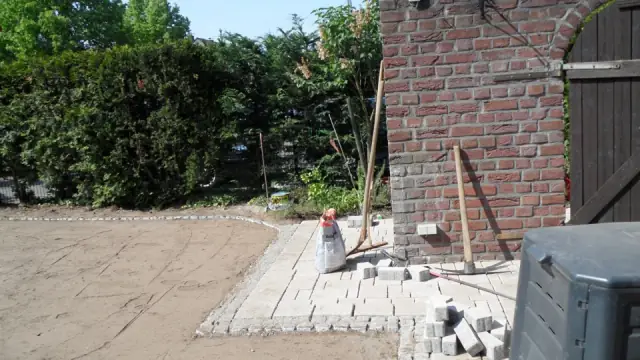 Werkzeug und erste Plattenreihen an einer Backstein-Hausecke