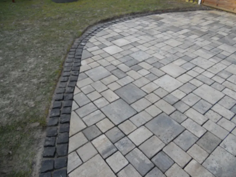 Fertig gepflasterte, geschwungene Wegefläche aus Natursteinplatten